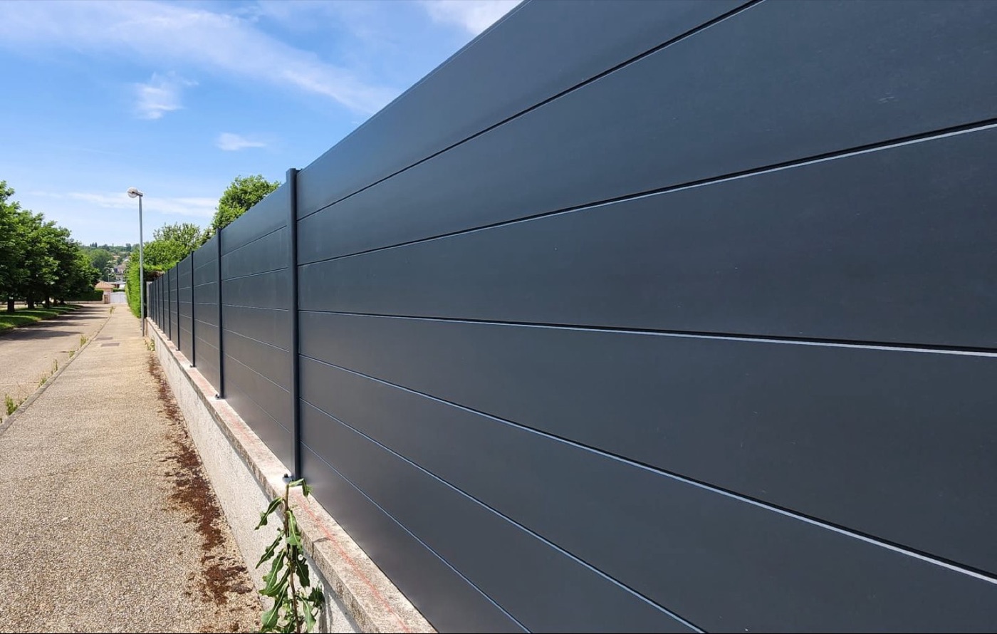 Longue clôture aluminium lames pleines anthracite sur muret
